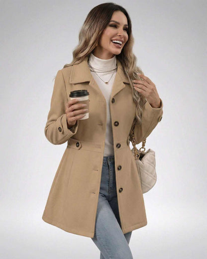 Smiling woman in a beige Milano Jacket, showcasing tailored design and slim fit, holding a coffee cup.