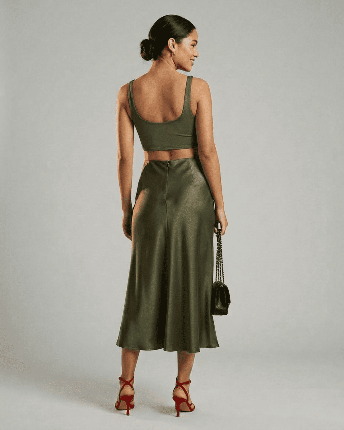 Olivia Midi Skirt in olive green, showcasing elegant satin fabric and a flattering silhouette in a stylish outfit.
