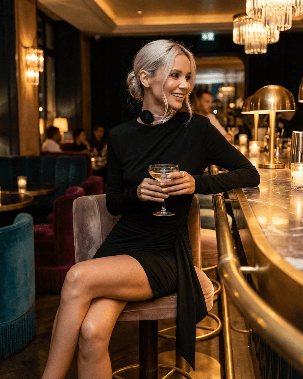 Woman wearing the Onyx Mini Dress sitting at a bar, showcasing its fitted bodycon style and sophisticated look.
