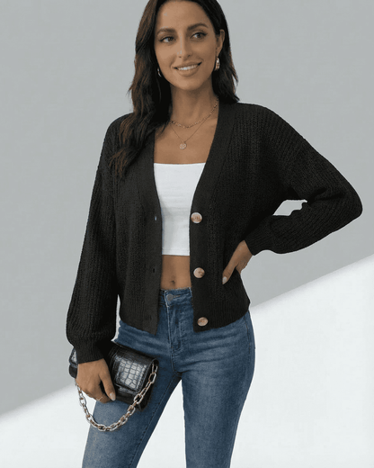 Model showcasing the Orion Cardigan in black, featuring a V-neckline and button-front design, paired with jeans.