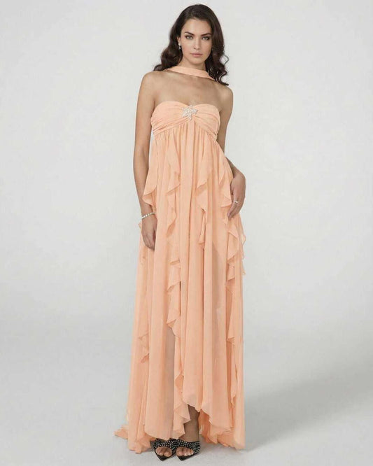 Peachira Maxi Dress worn by a model, featuring ruffle details and a strapless design in soft peach color.