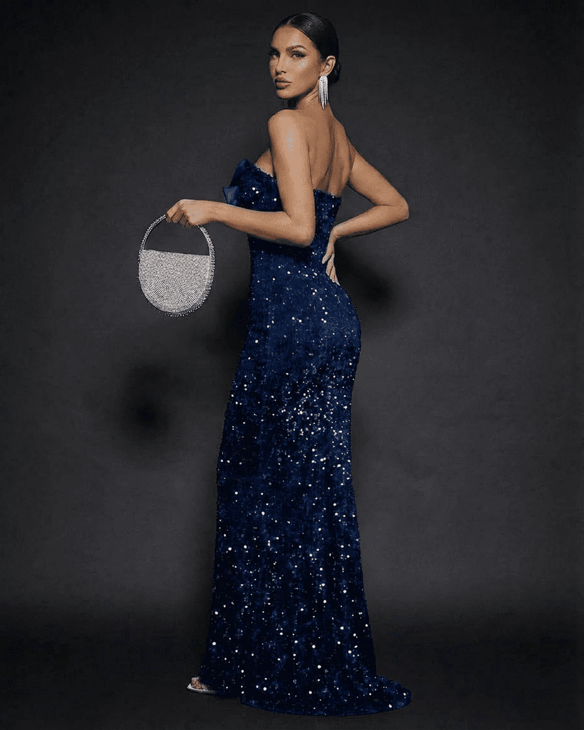Sapphire Maxi Dress model showcasing a strapless bow sequin design against a dark backdrop.