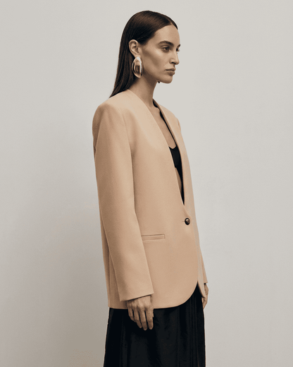 Savona Blazer on model featuring a beige fitted single-breasted design with a V-neckline.
