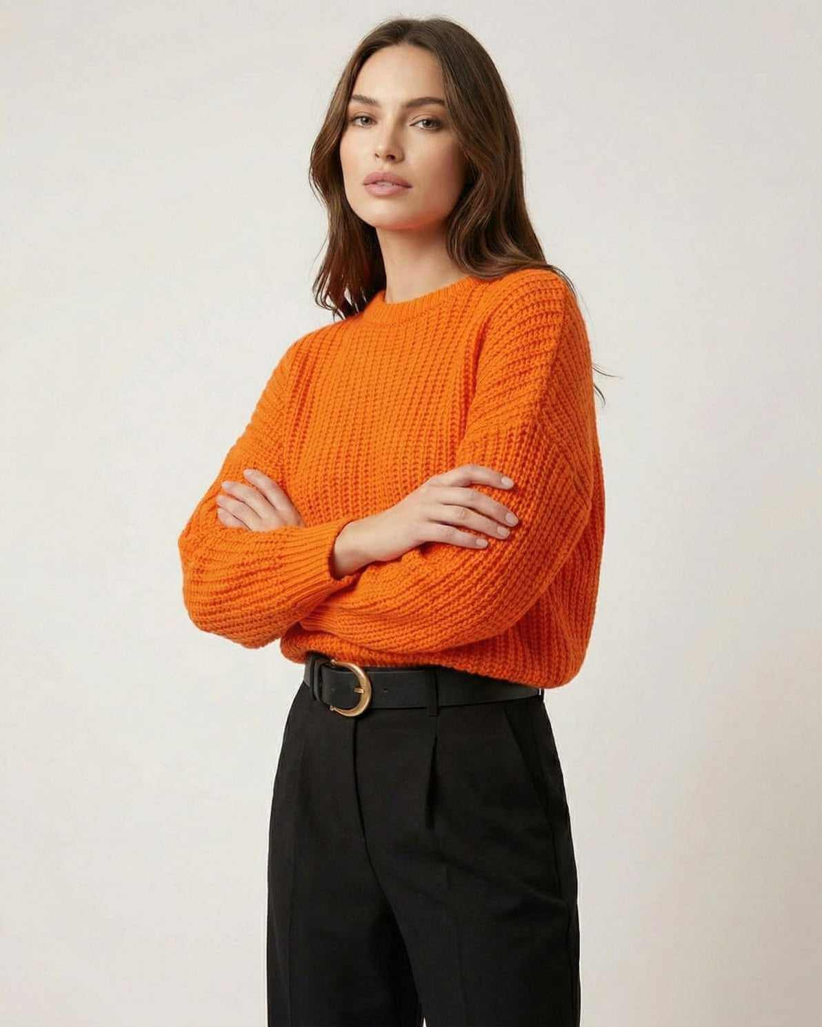 Sienna Sweater in bright orange knit texture, featuring a relaxed silhouette and paired with stylish black trousers.