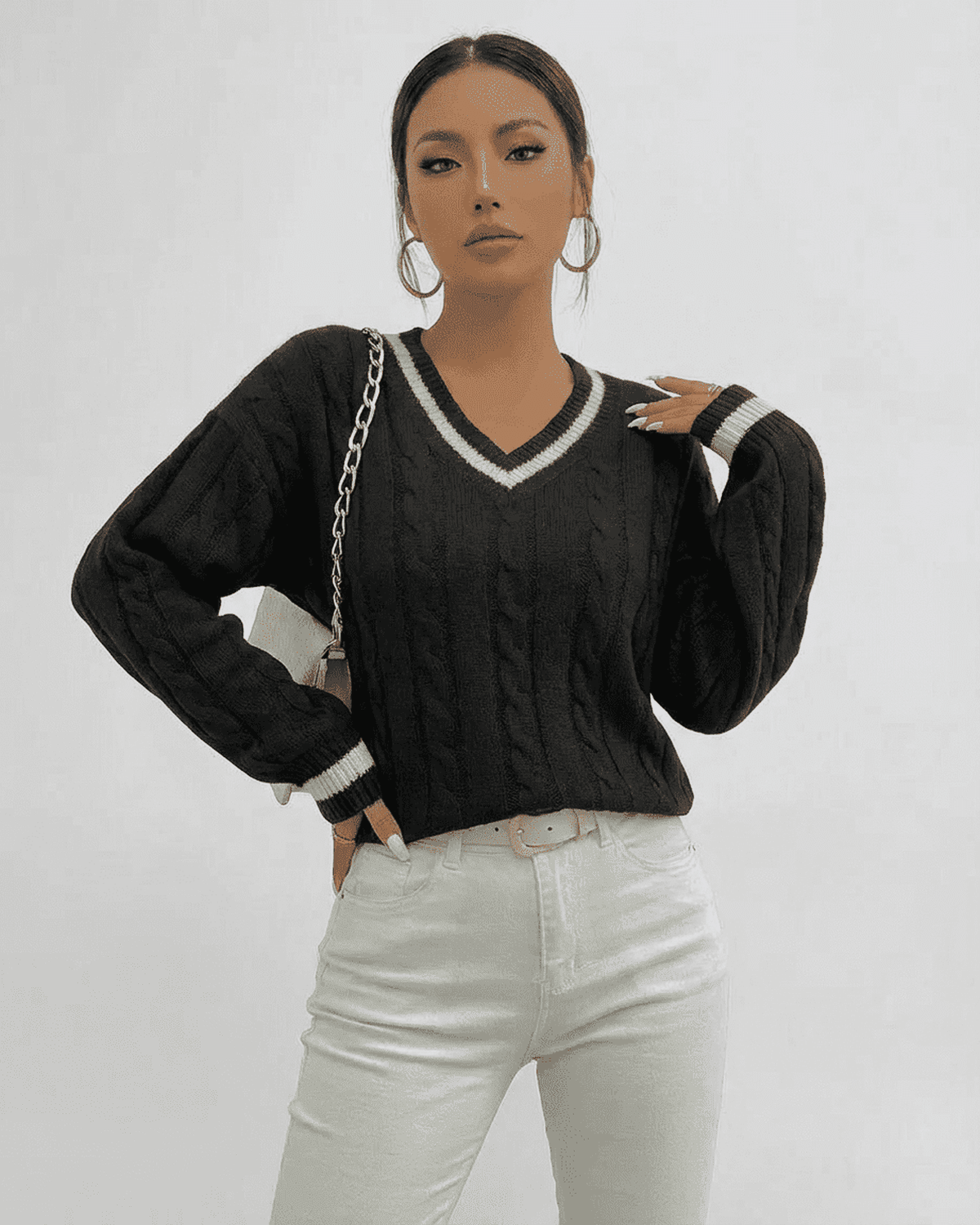 Verona Sweater - Cable Knit V-Neck Pullover by RAMBLION in black worn with white jeans.